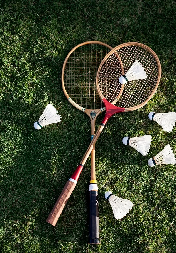 Badminton racquets and shuttlecocks on grass